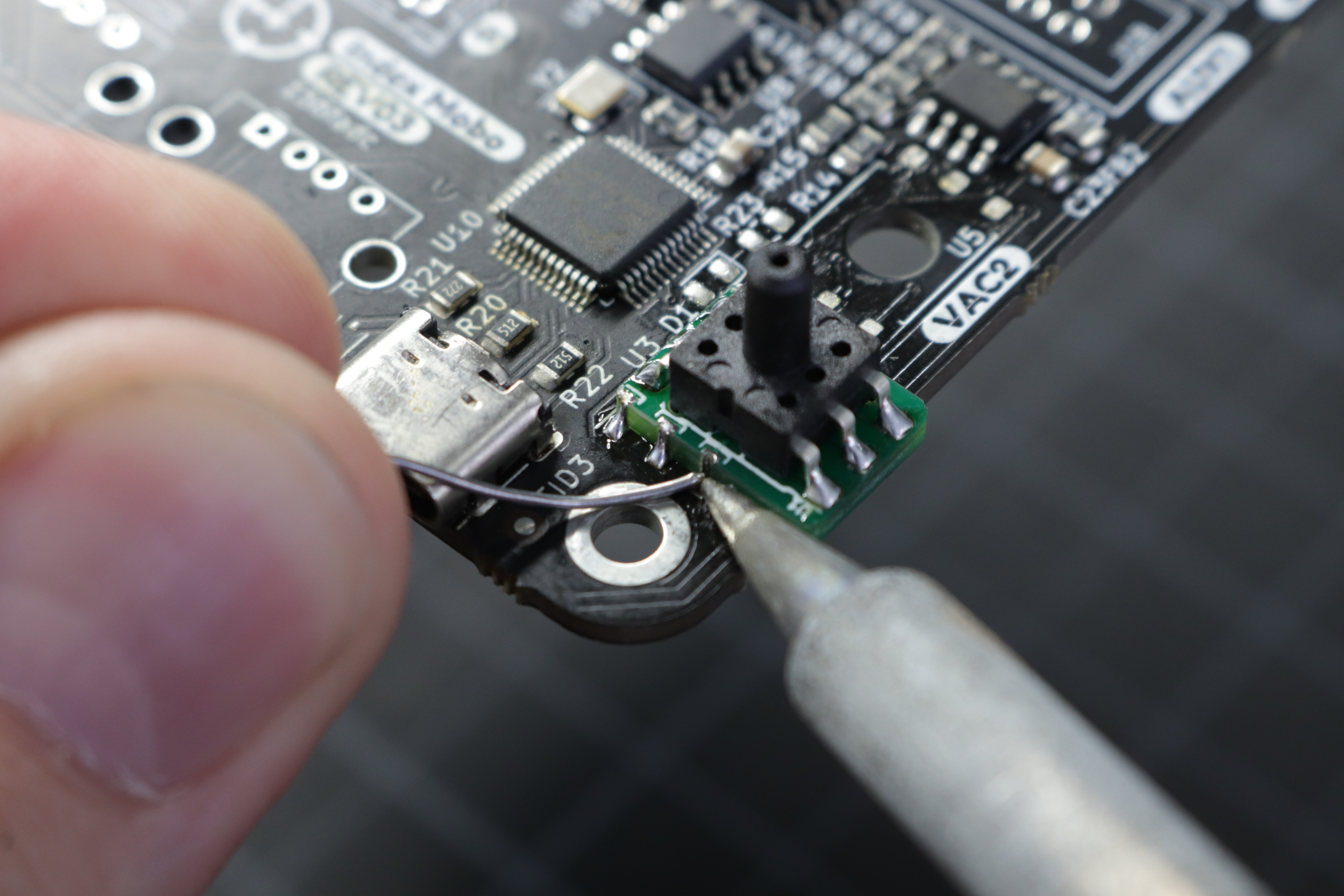 A photo of solder being applied to the interposer plated edges and the corresponding PCB pads