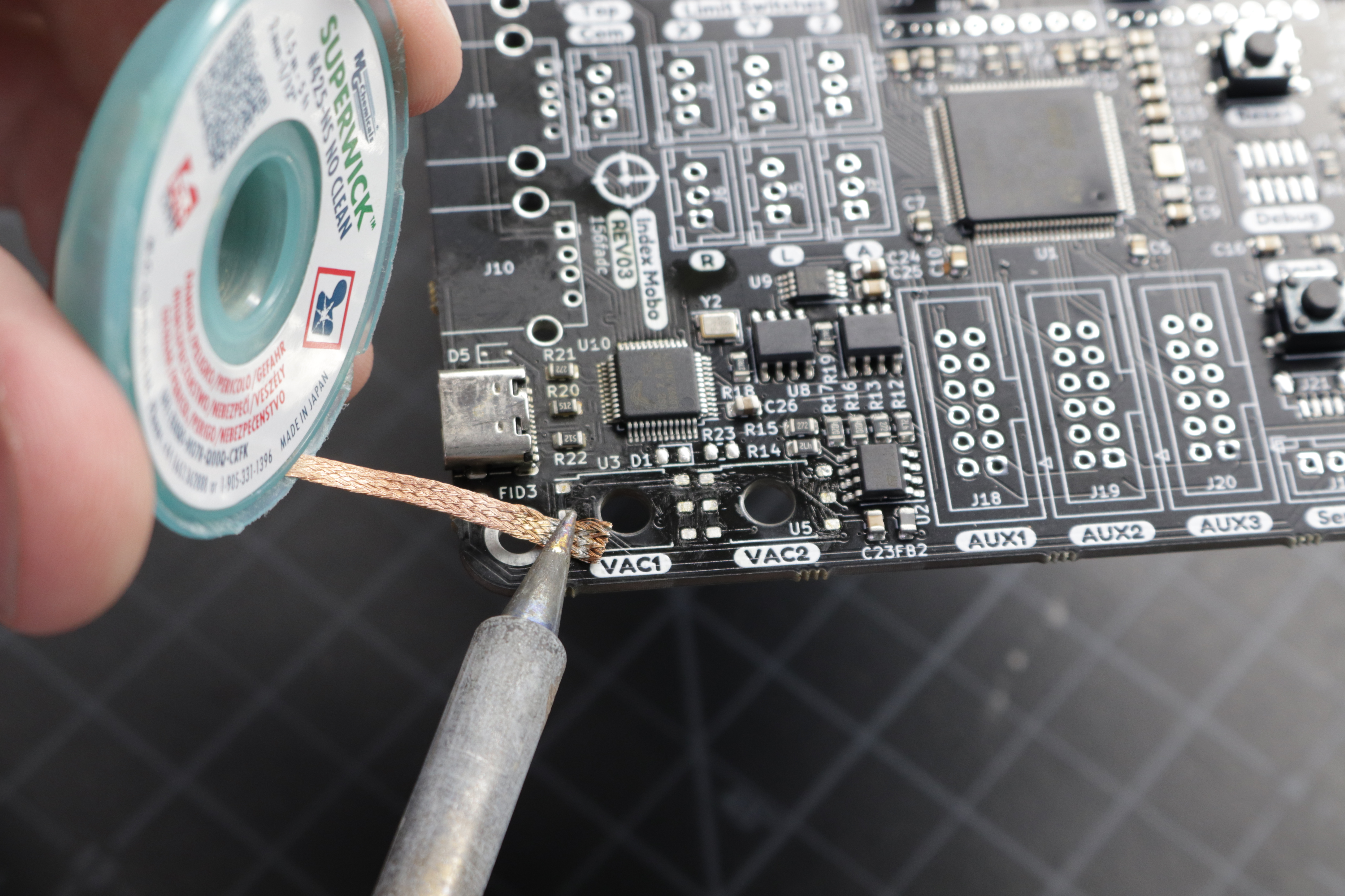 A photo of solder wick being used to clean the pads